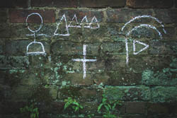 Hobo code, signs in chalk on a masonry wall. Image by Antique Archeology